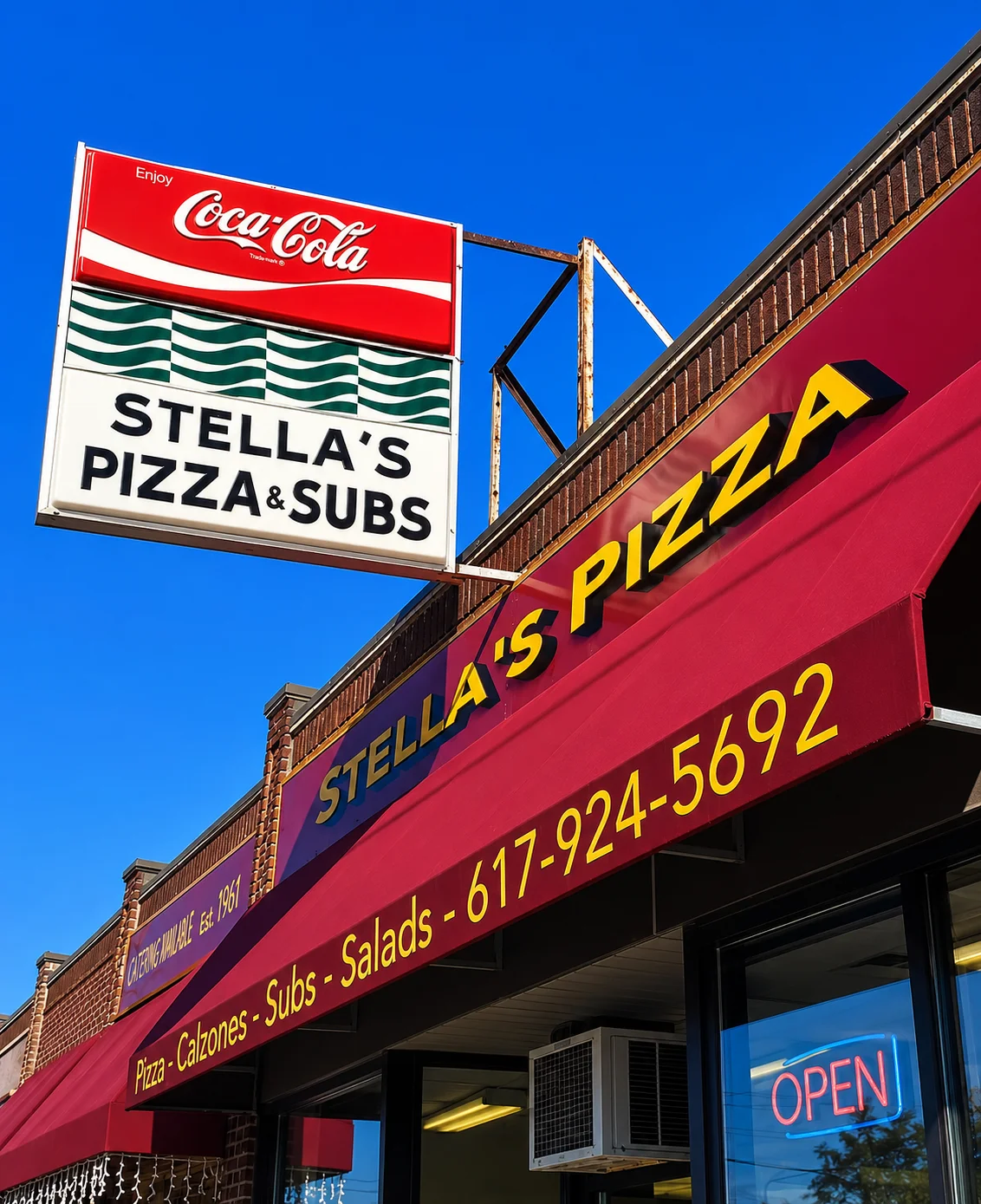 Stella's Pizza & Subs restaurant sign with red awning