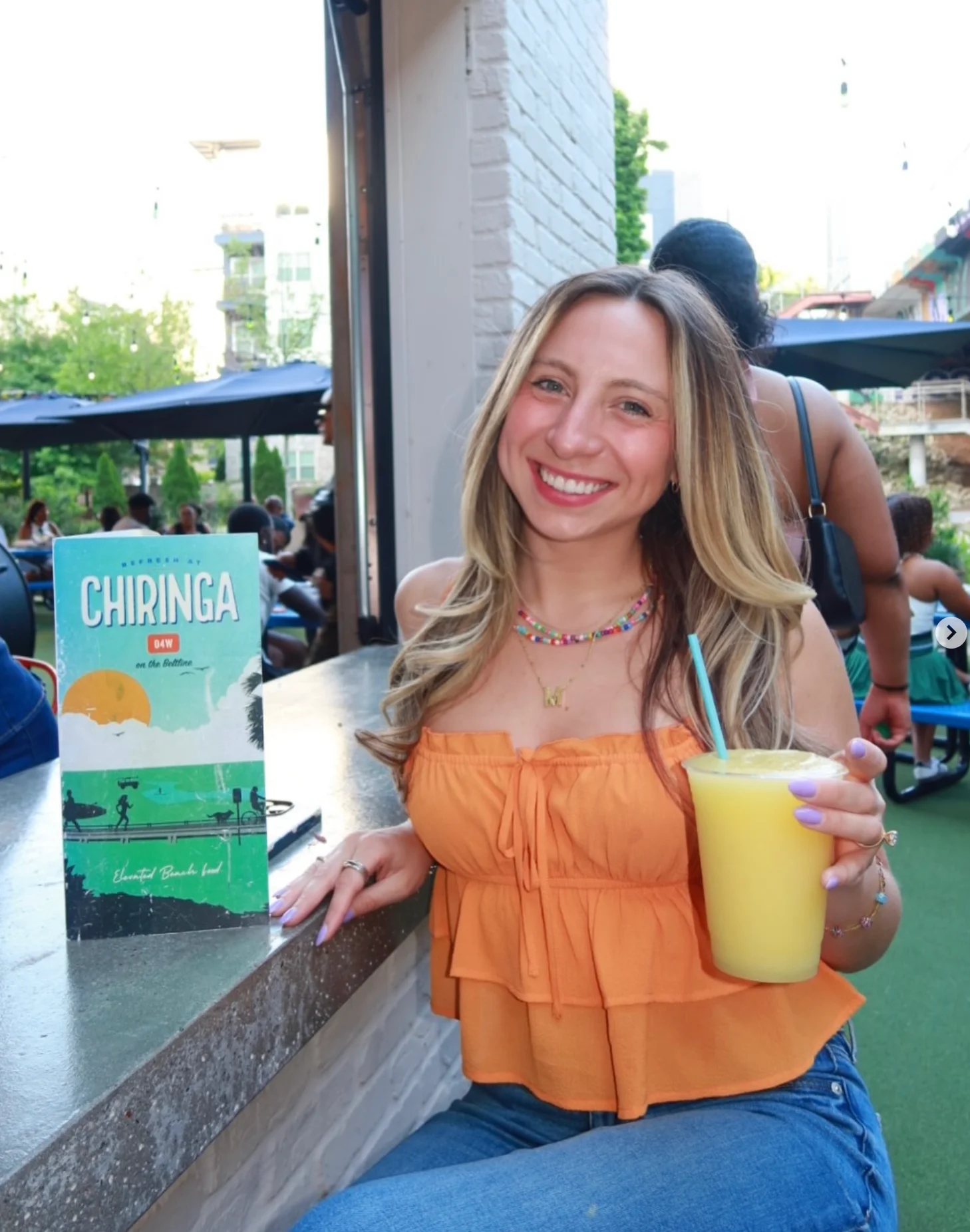 Young woman smiling and enjoying a CHIRINGA cocktail