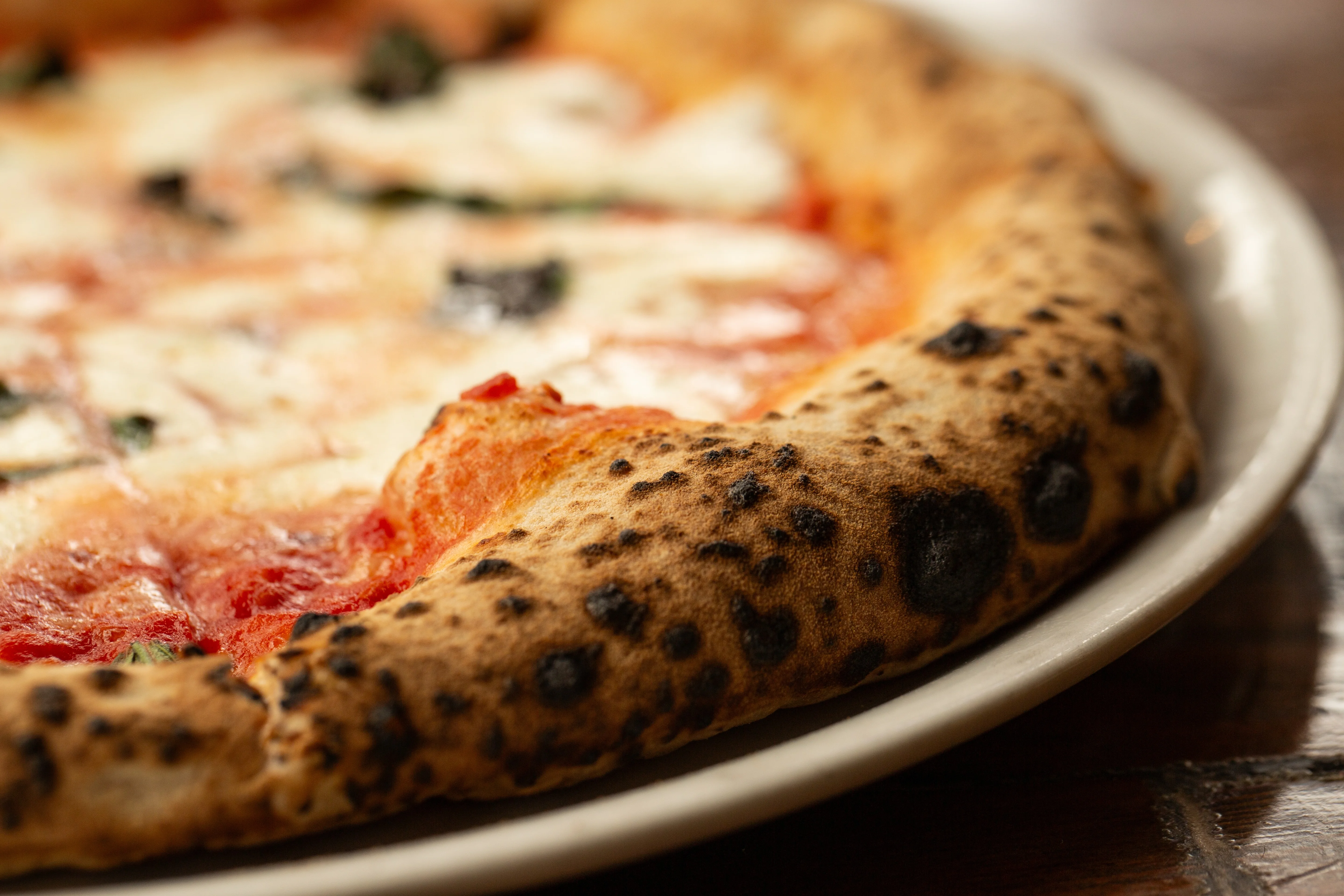 Margherita pizza with a charred crust from a wood-fired oven