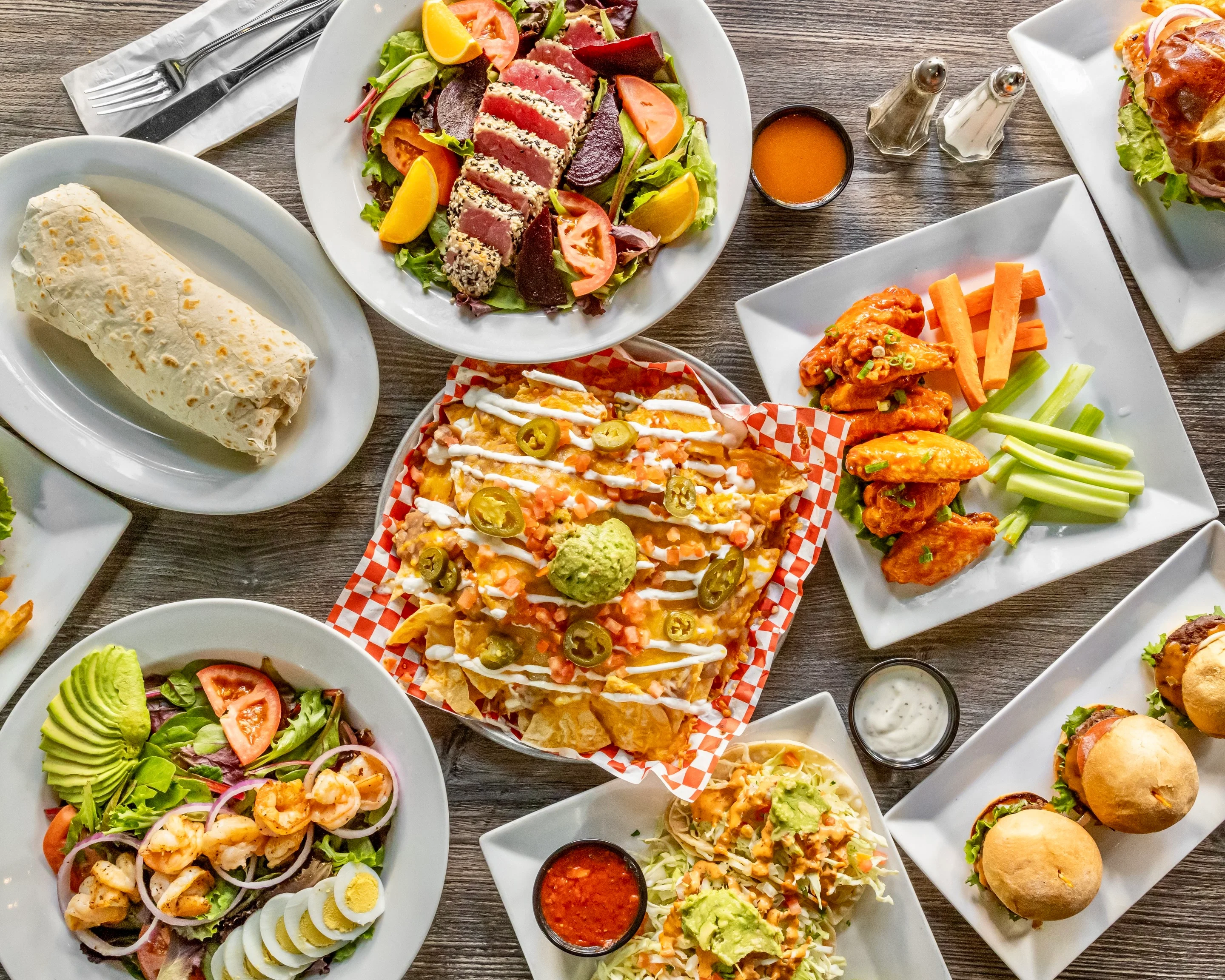 Colorful platter of nachos with guacamole and wings