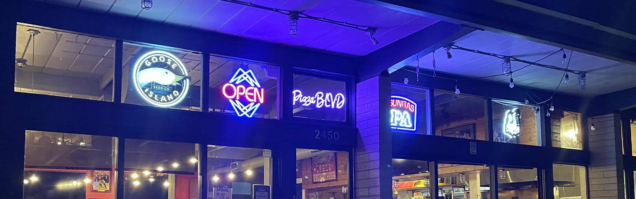 Cozy restaurant exterior with neon signs at night