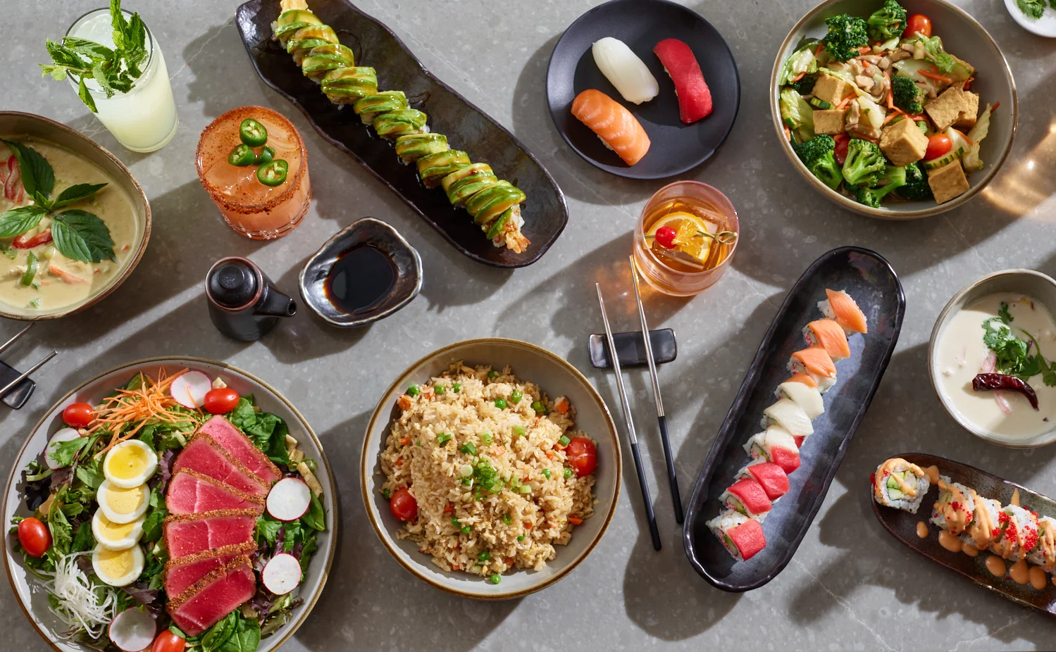Assorted sushi and Asian dishes on a dining table