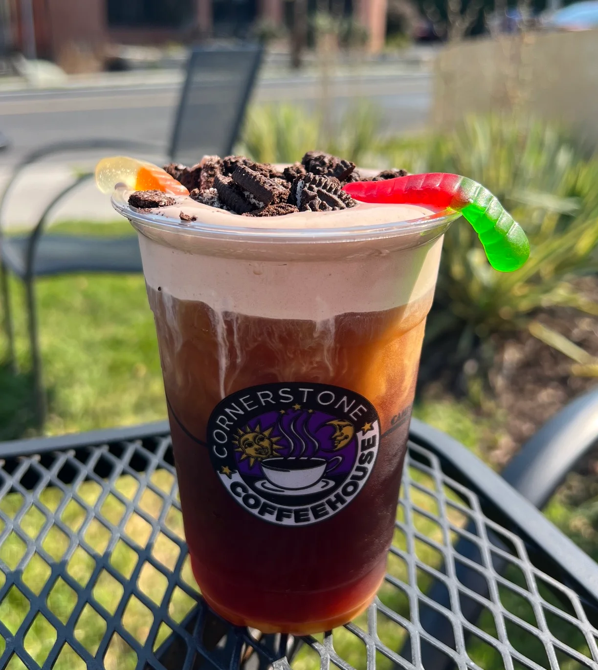 Iced chocolate coffee drink topped with cookie pieces and gummy worms