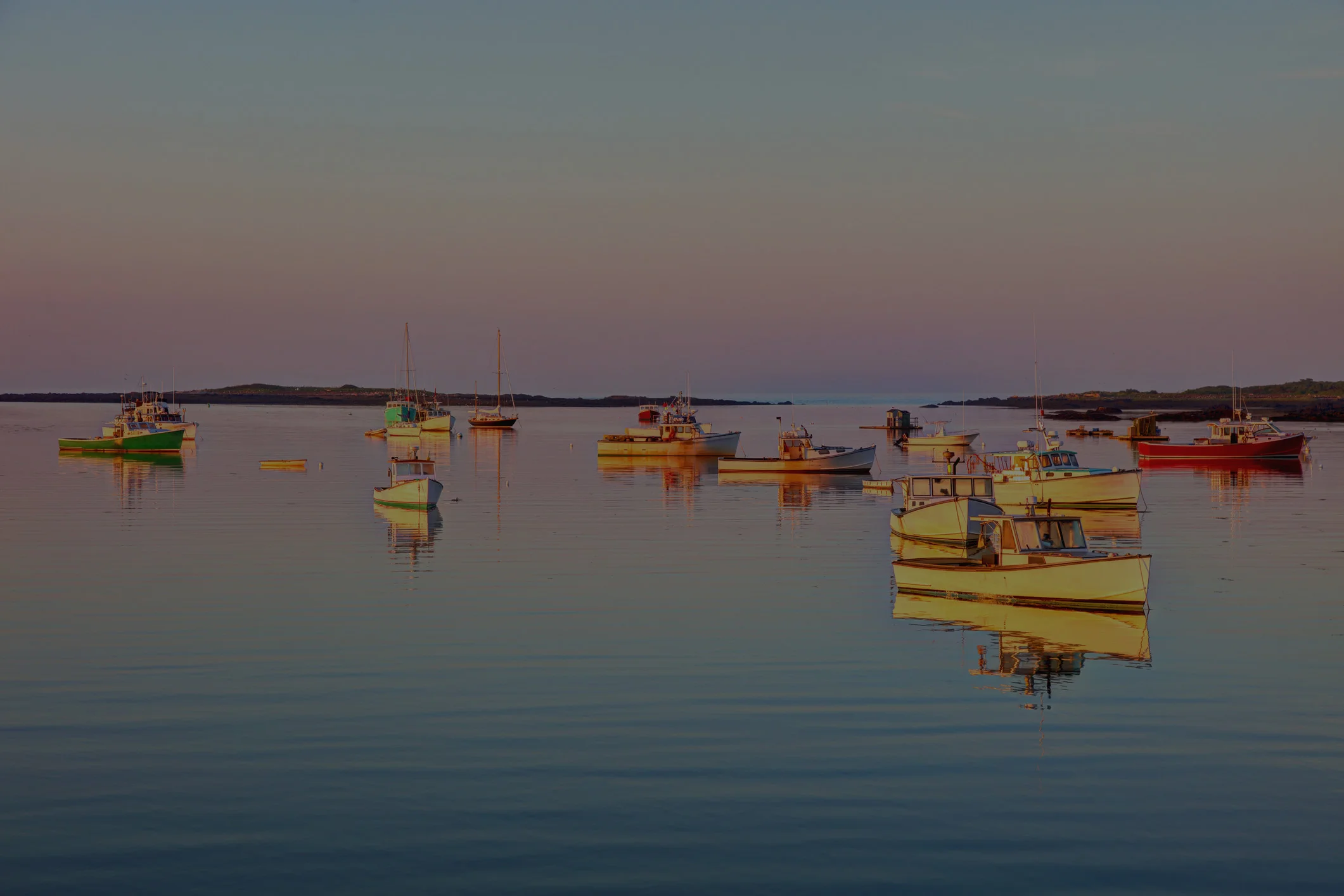 Colorful fishing boats on calm water at sunset