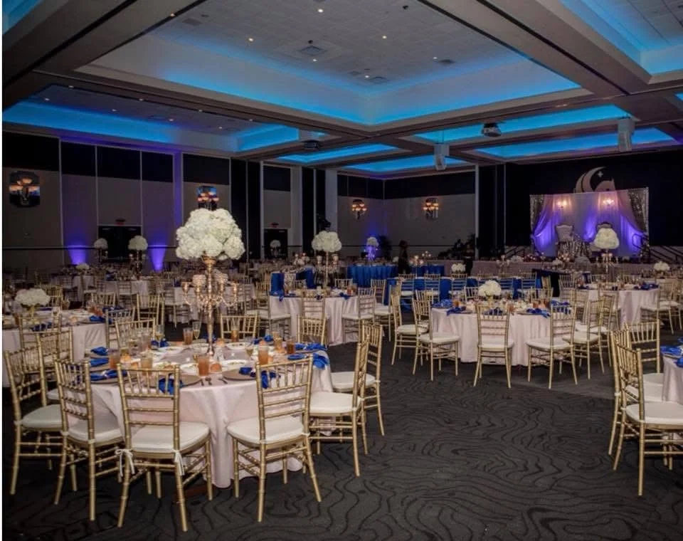 Elegant banquet hall set for a formal event with floral centerpieces