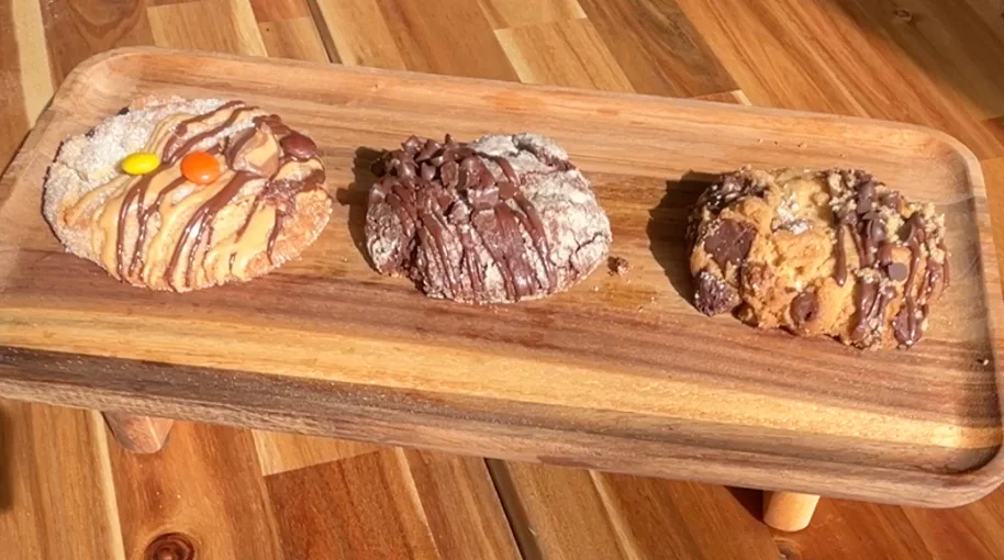 Assorted gourmet cookies on a wooden platter