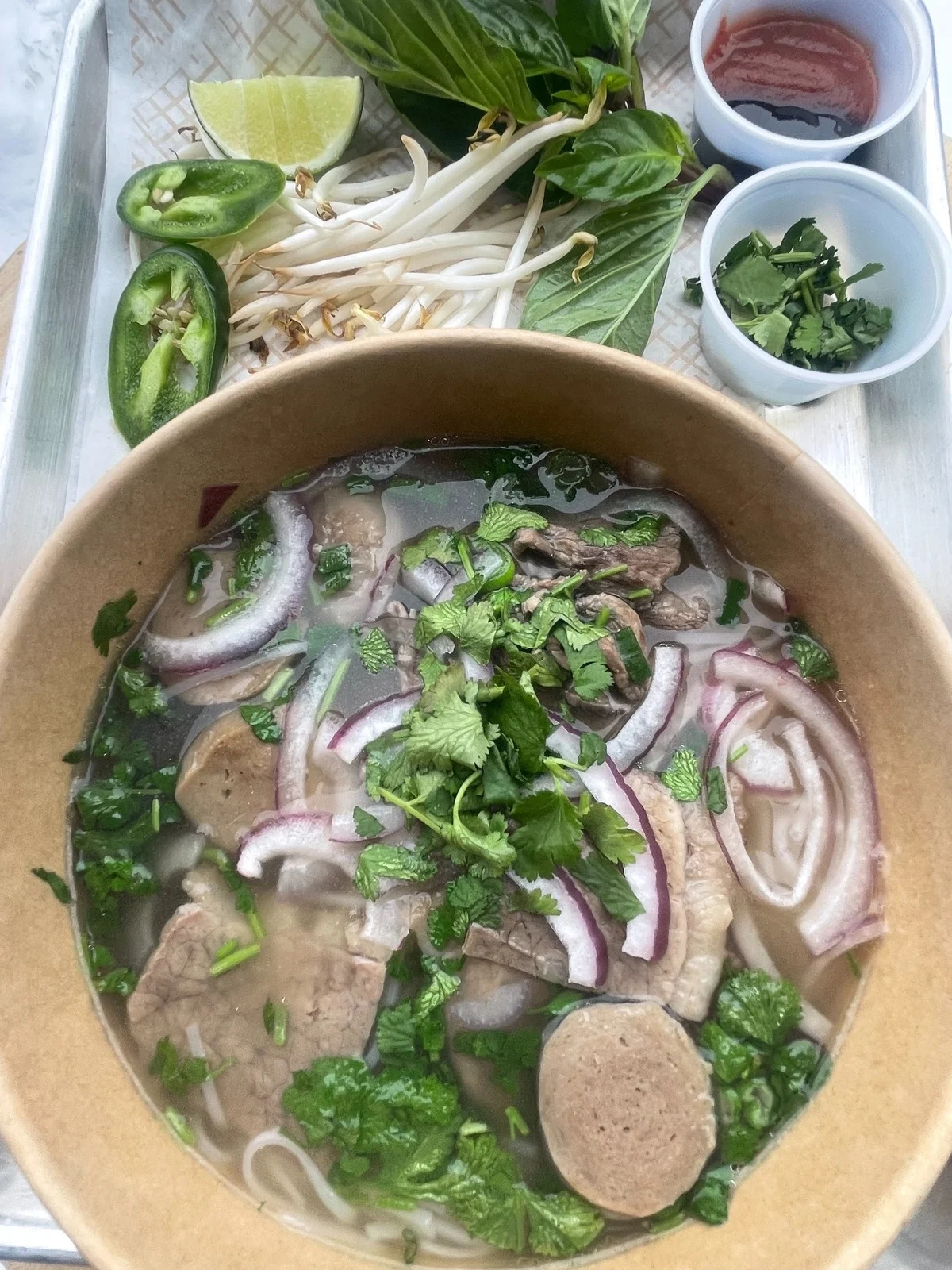 Bowl of Vietnamese pho with beef and fresh herbs