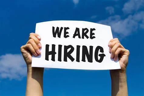 Sign displaying 'We Are Hiring' against a blue sky