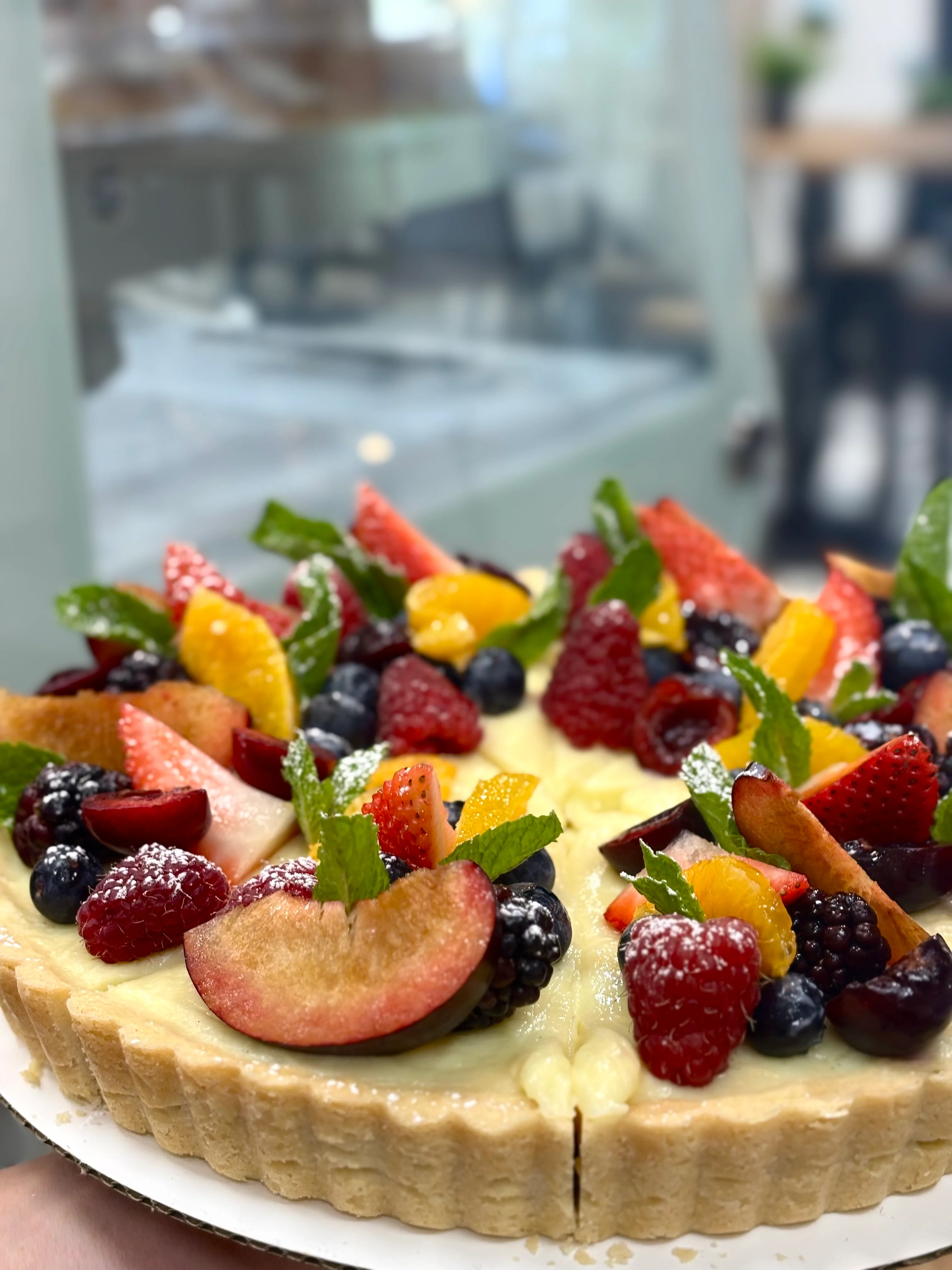 Colorful fruit tart with seasonal berries and mint garnish