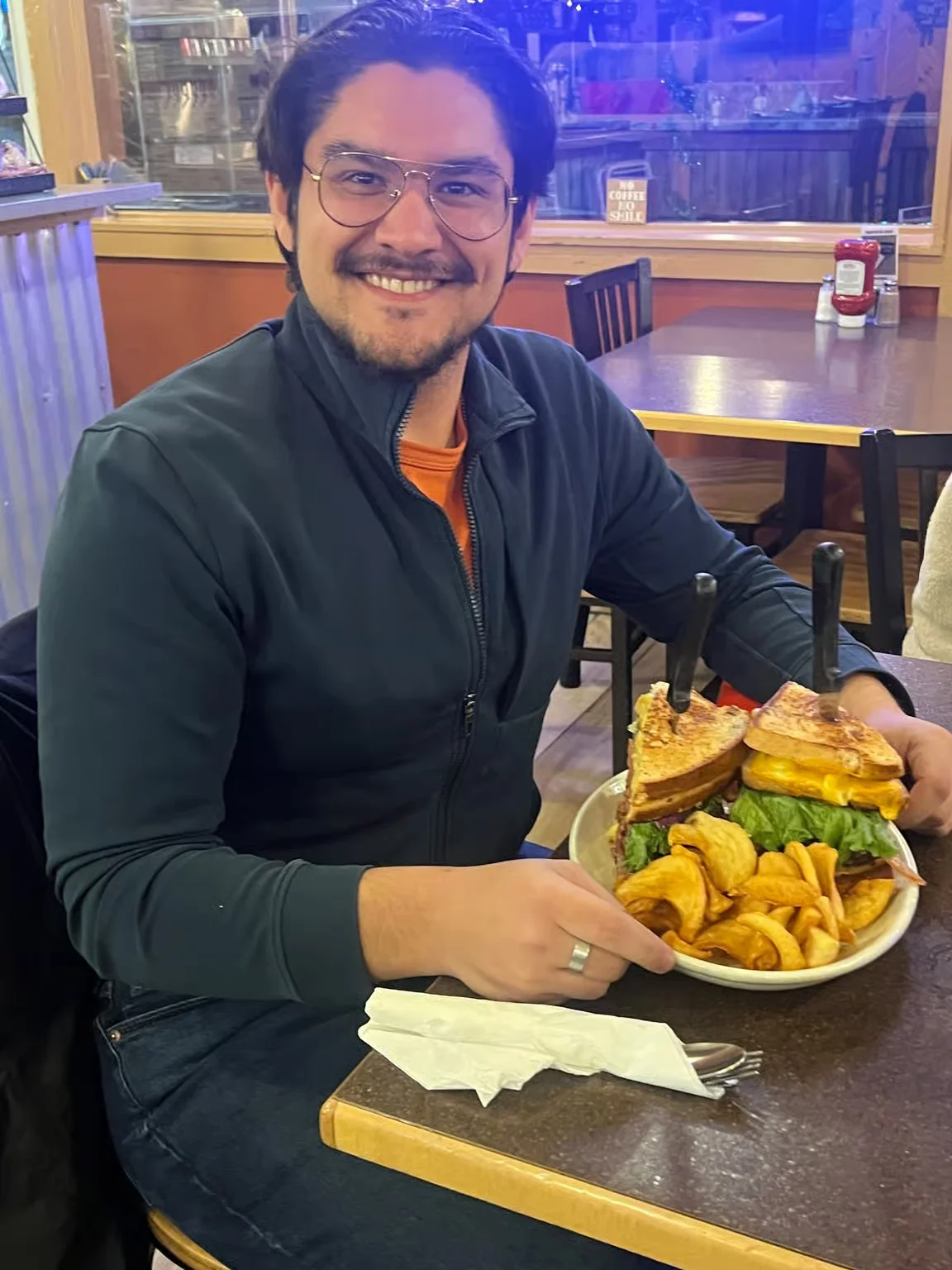 Giant cheeseburger with fries in a cozy diner setting