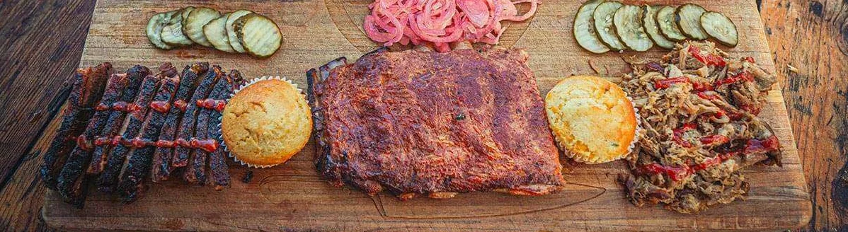 Southern barbecue platter with ribs, pulled pork, and cornbread
