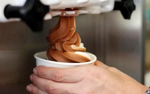 Fresh vanilla soft serve being swirled into a cup at Countryside Drive-In. The creamy, smooth ice cream pours perfectly from our modern soft serve machine in a clean, inviting environment, ready to satisfy your sweet tooth