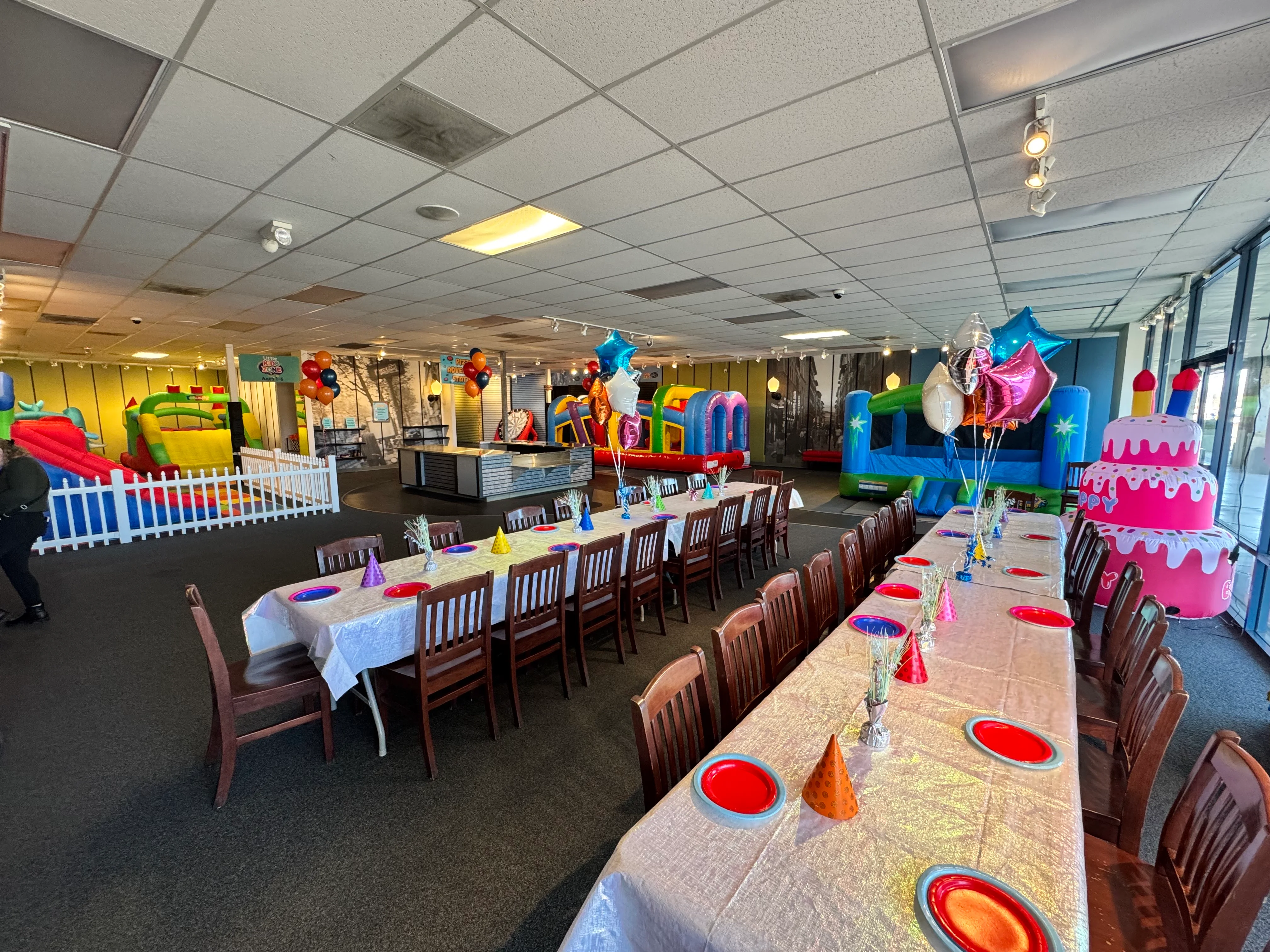Colorful party venue with tables and inflatable attractions