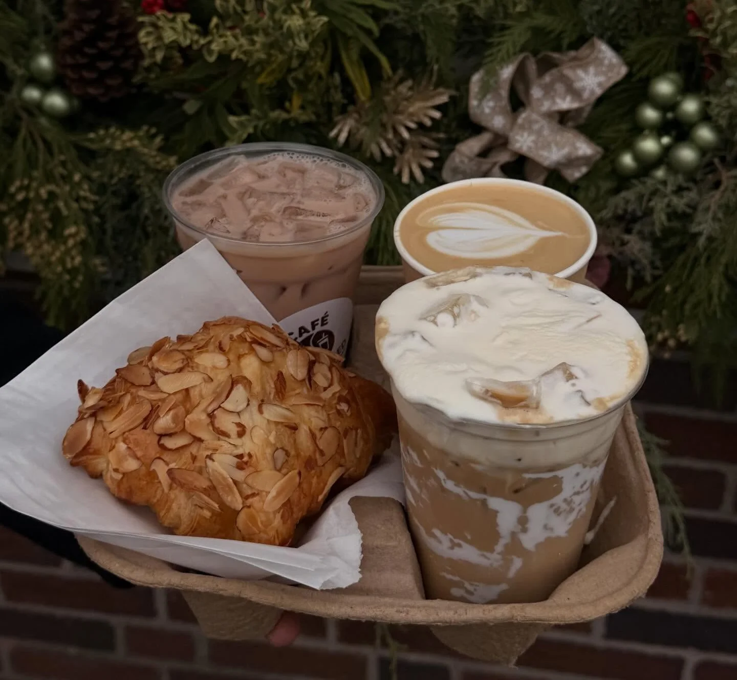 Assorted coffee drinks and almond croissant on a festive background