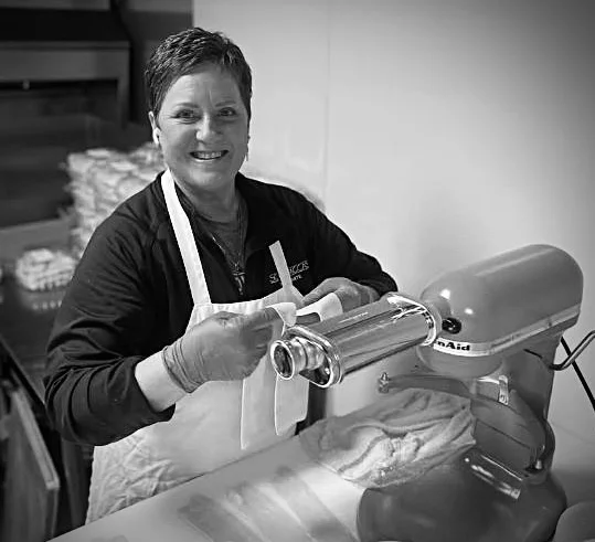 Chef preparing fresh pasta with a pasta machine