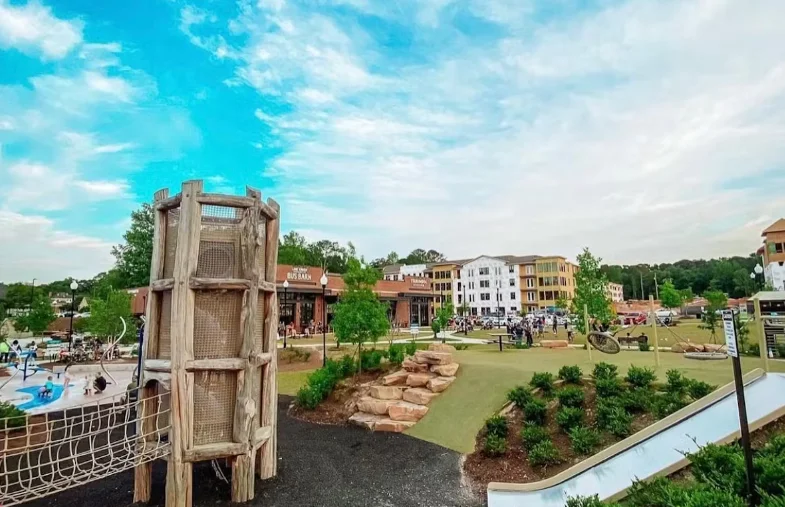 Playground with climbing structure and modern buildings in the background