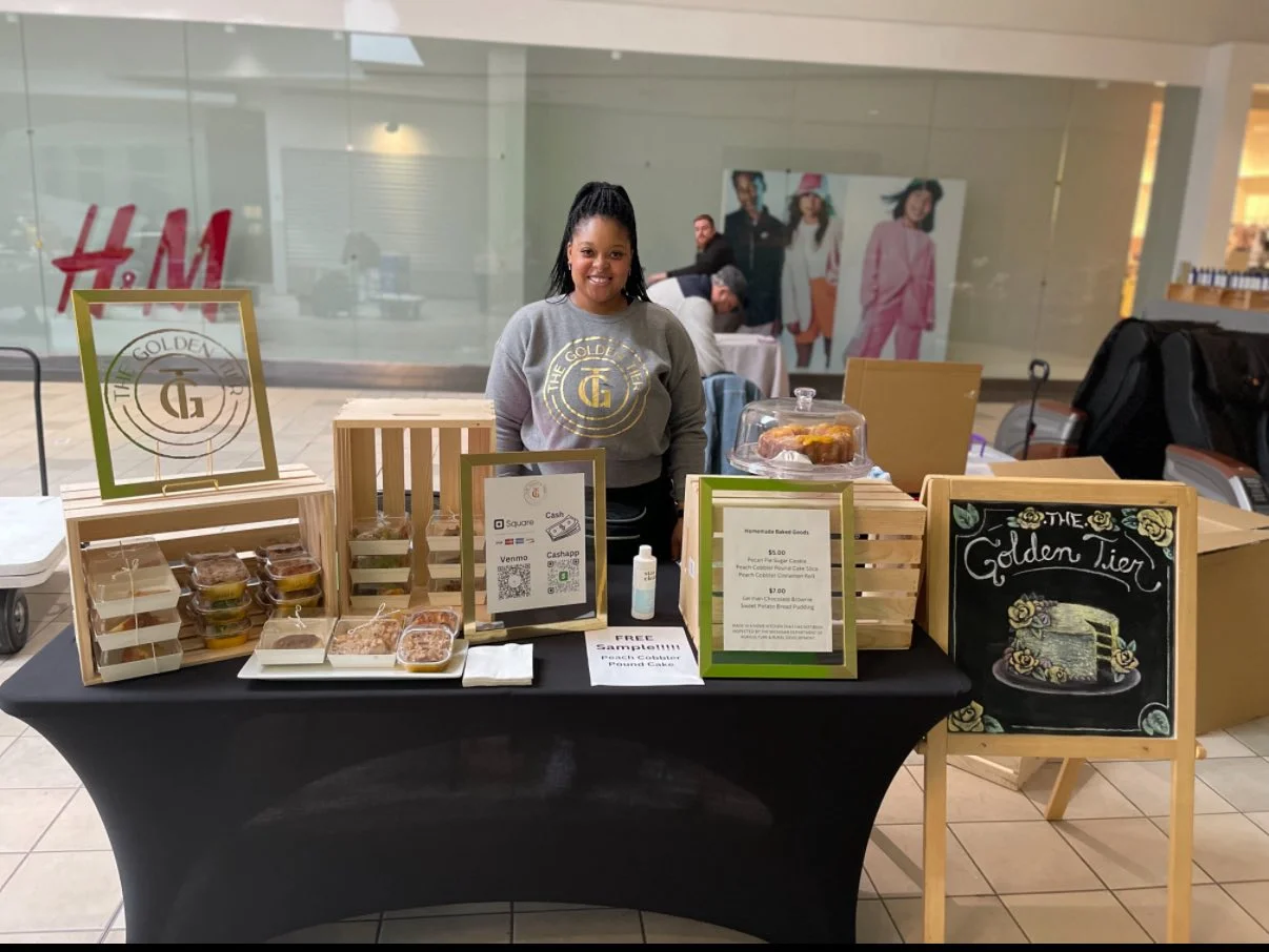 Vendor showcasing homemade baked goods at a market stall