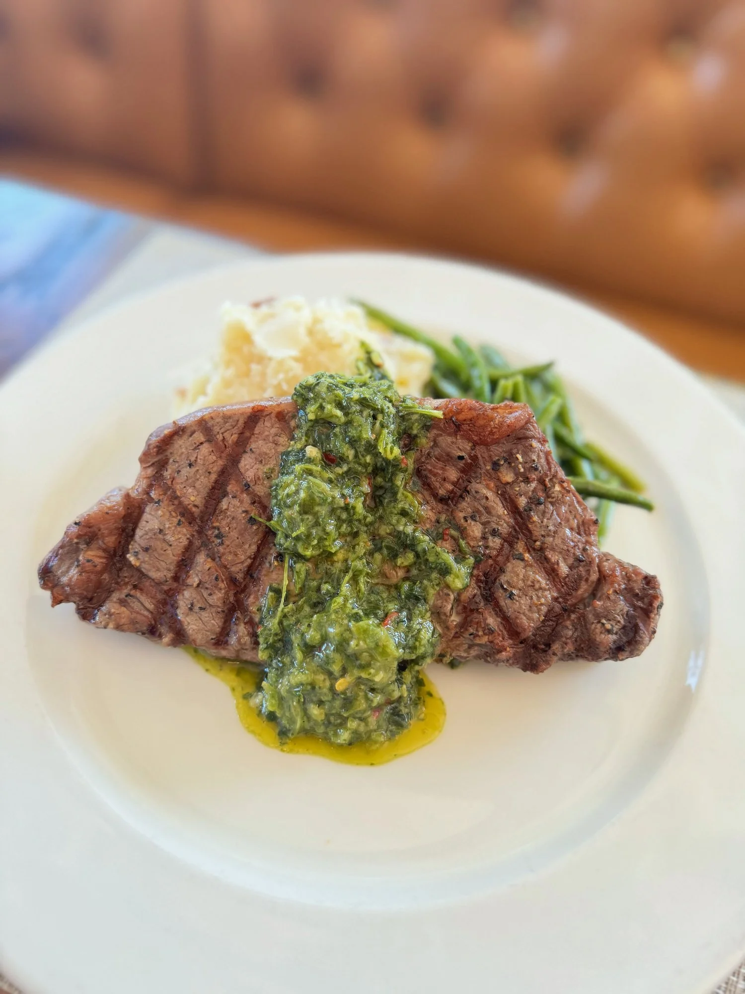 Grilled steak with chimichurri sauce, served with sides