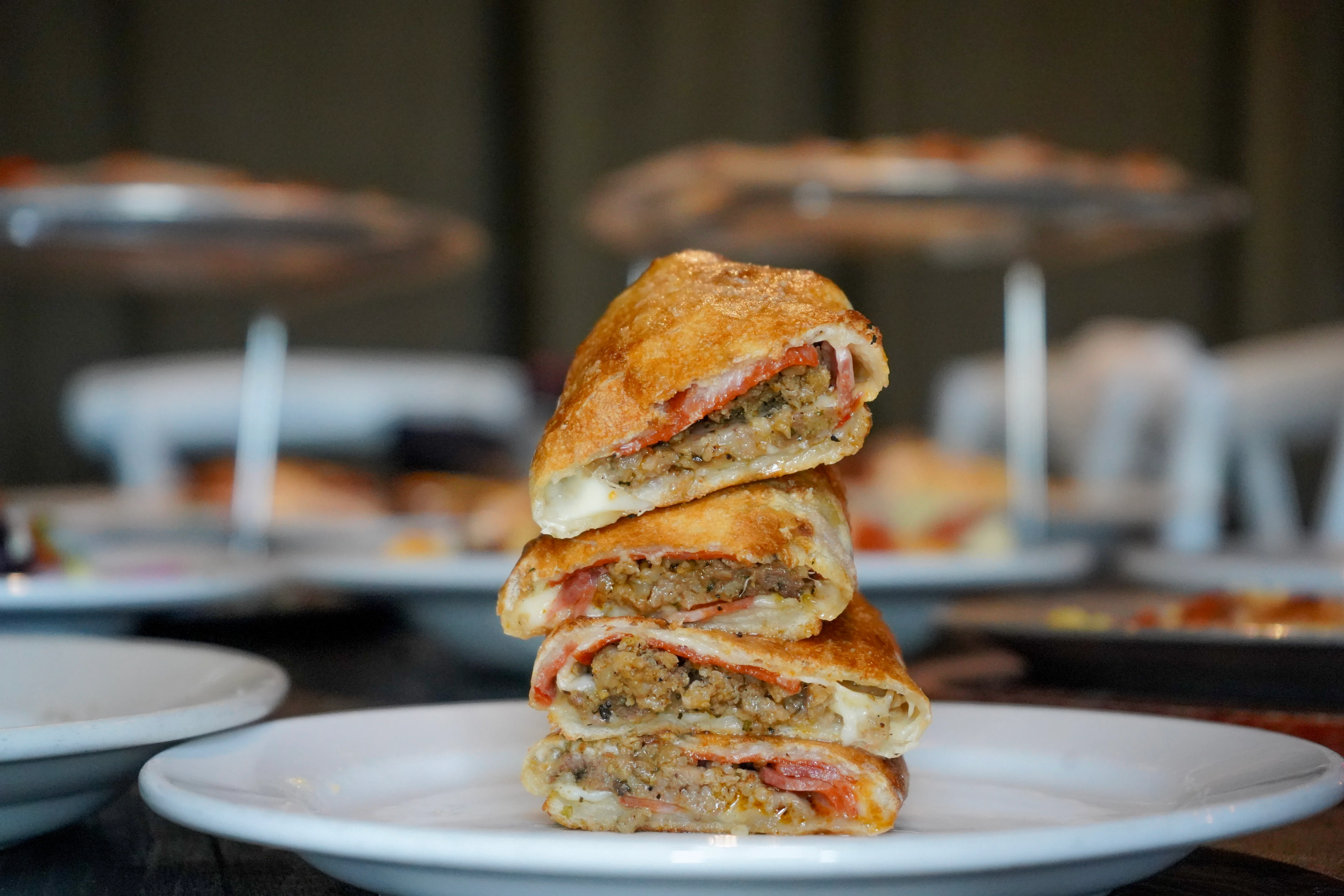 Italian calzone stacked on white plates