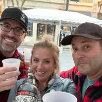 Three friends smiling together at a restaurant.
