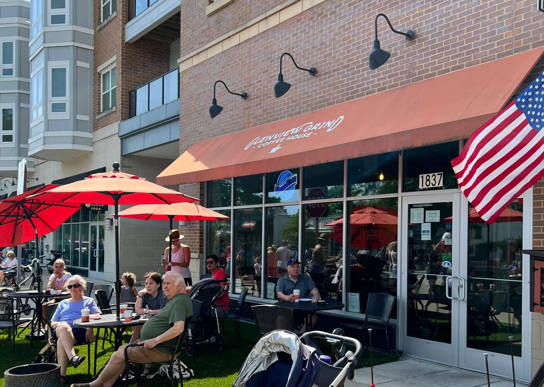 Outdoor café seating with umbrellas and families enjoying coffee