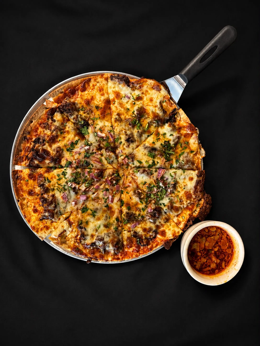 Delicious pepperoni pizza with herbs and chili oil