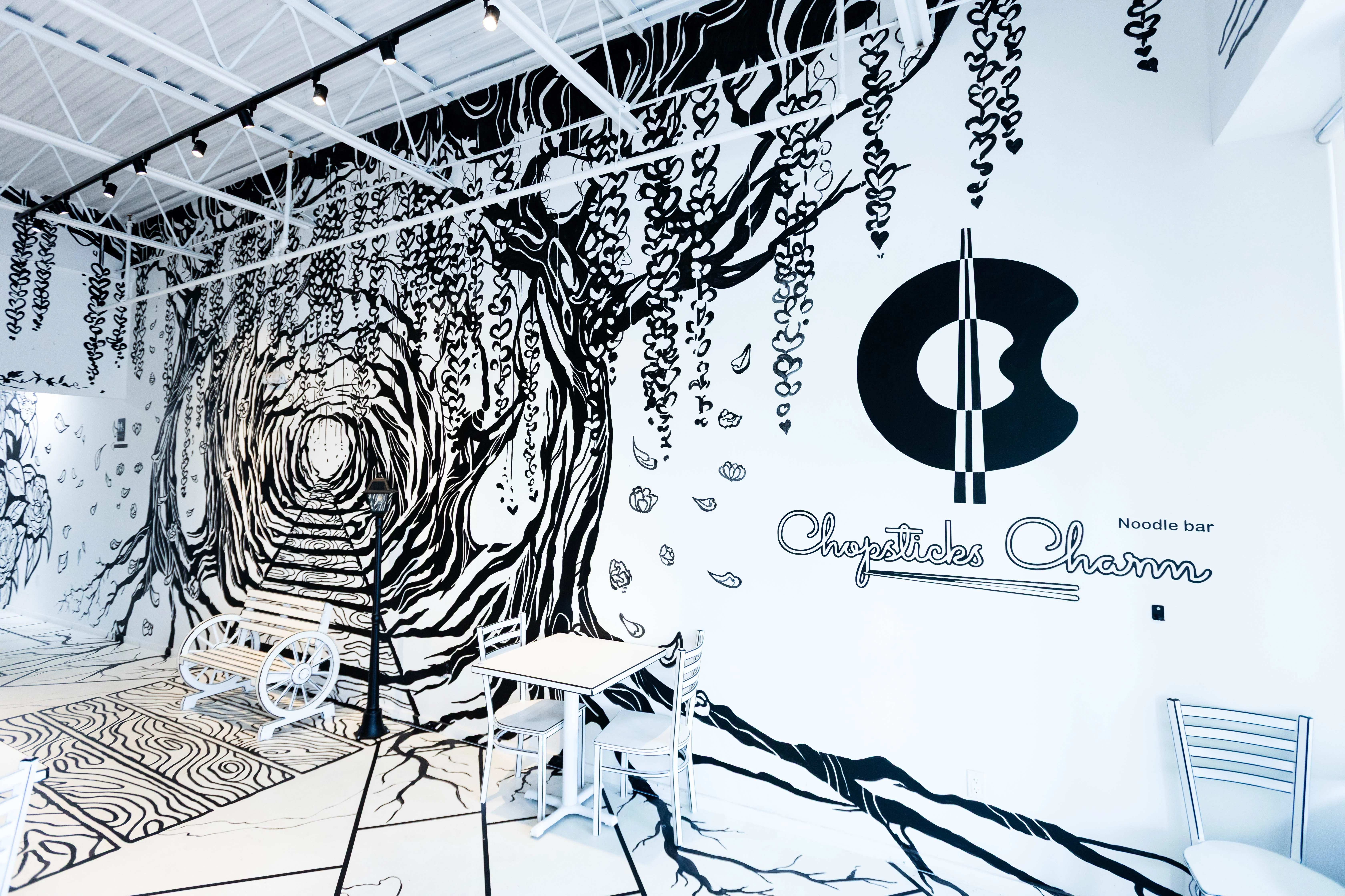 The unique 2-D cartoon-themed interior of Chopsticks Charm, where the walls, tables, and chairs are designed to look like a black and white drawing.