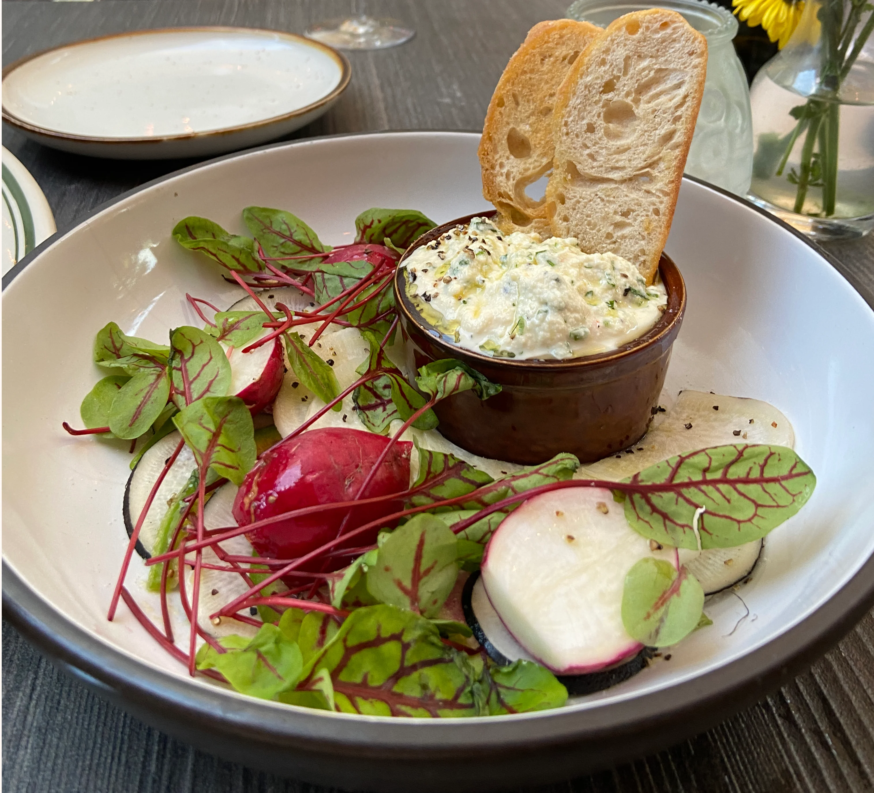 Creamy dip served with fresh greens and toasted bread