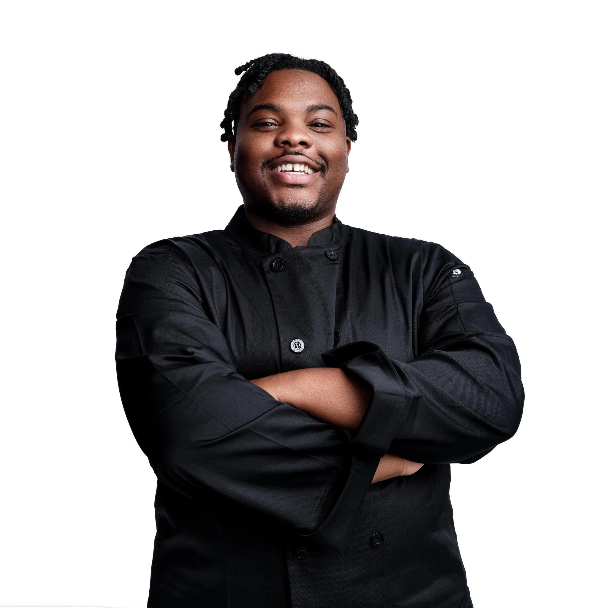 Chef in a black uniform smiling confidently