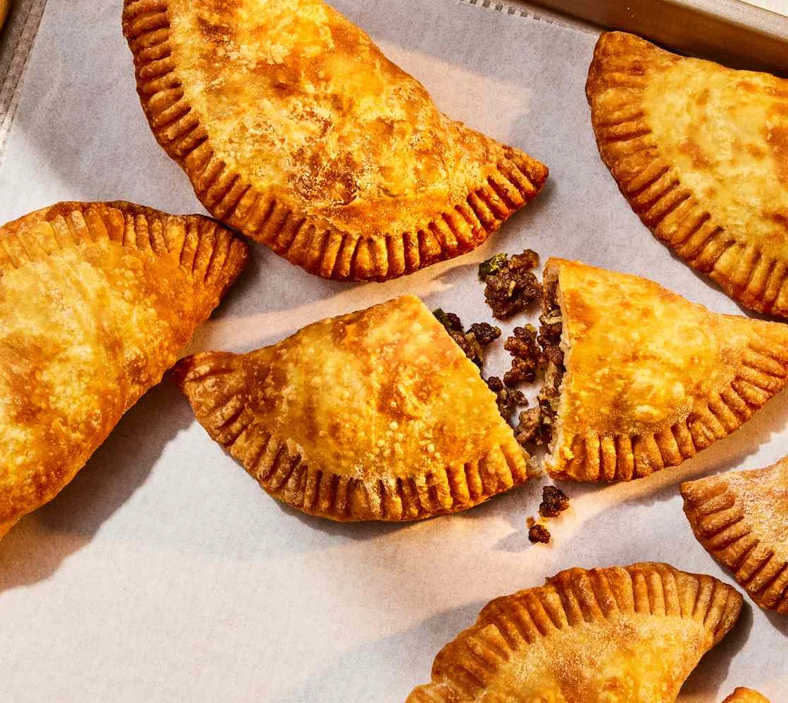 Golden empanadas on a baking tray