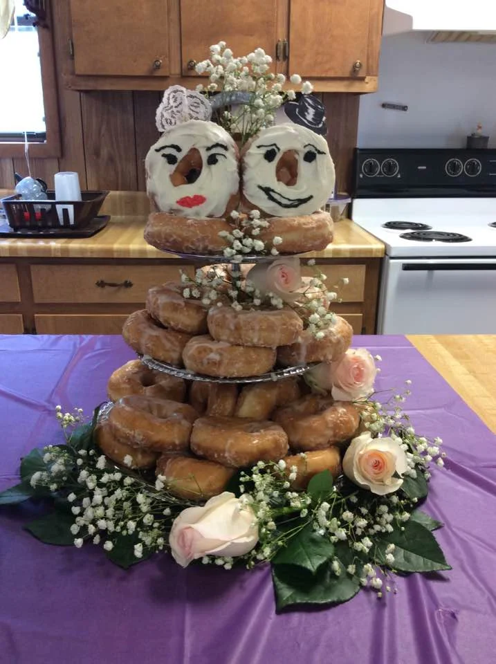 Creative wedding donut cake with decorated donut faces