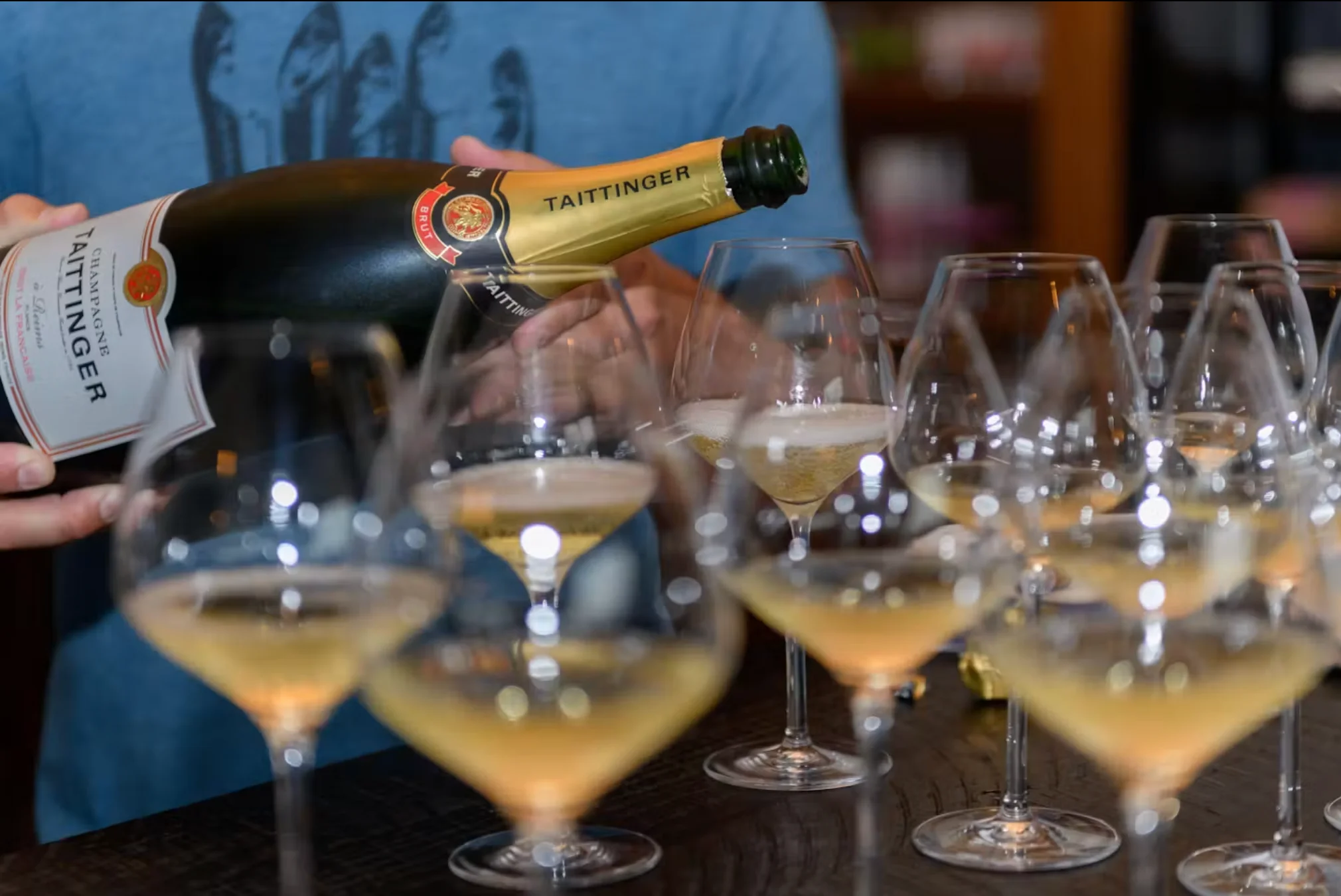 Pouring Taittinger champagne into elegant glasses for a tasting event