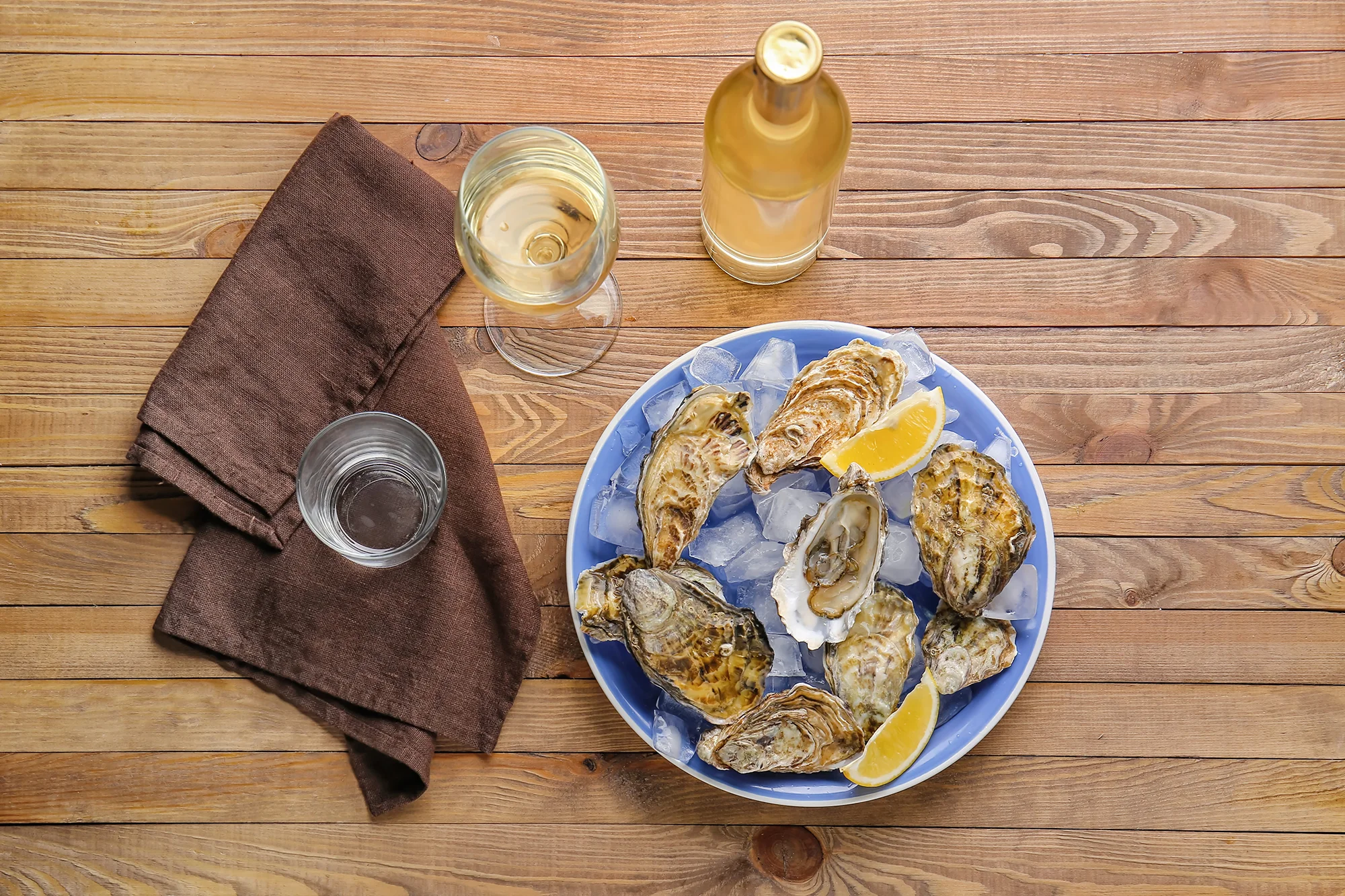 Fresh oysters on ice with lemon wedges