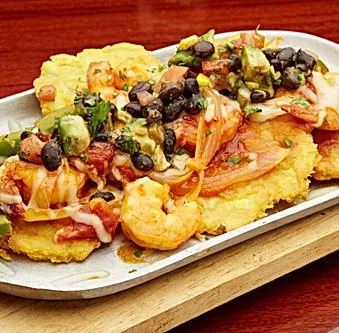Delicious shrimp tostones topped with black beans and fresh salsa