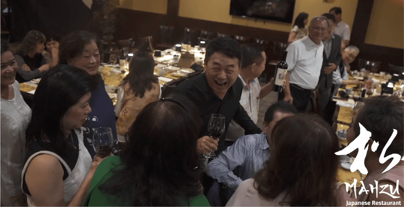 Guests raising wine glasses at a lively party at Mahzu East Windsor, BYOB with no corkage fee