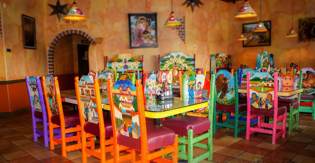 Vibrant restaurant interior with colorful chairs and artistic decor