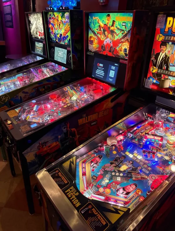 Colorful pinball machines in a lively arcade entertainment venue