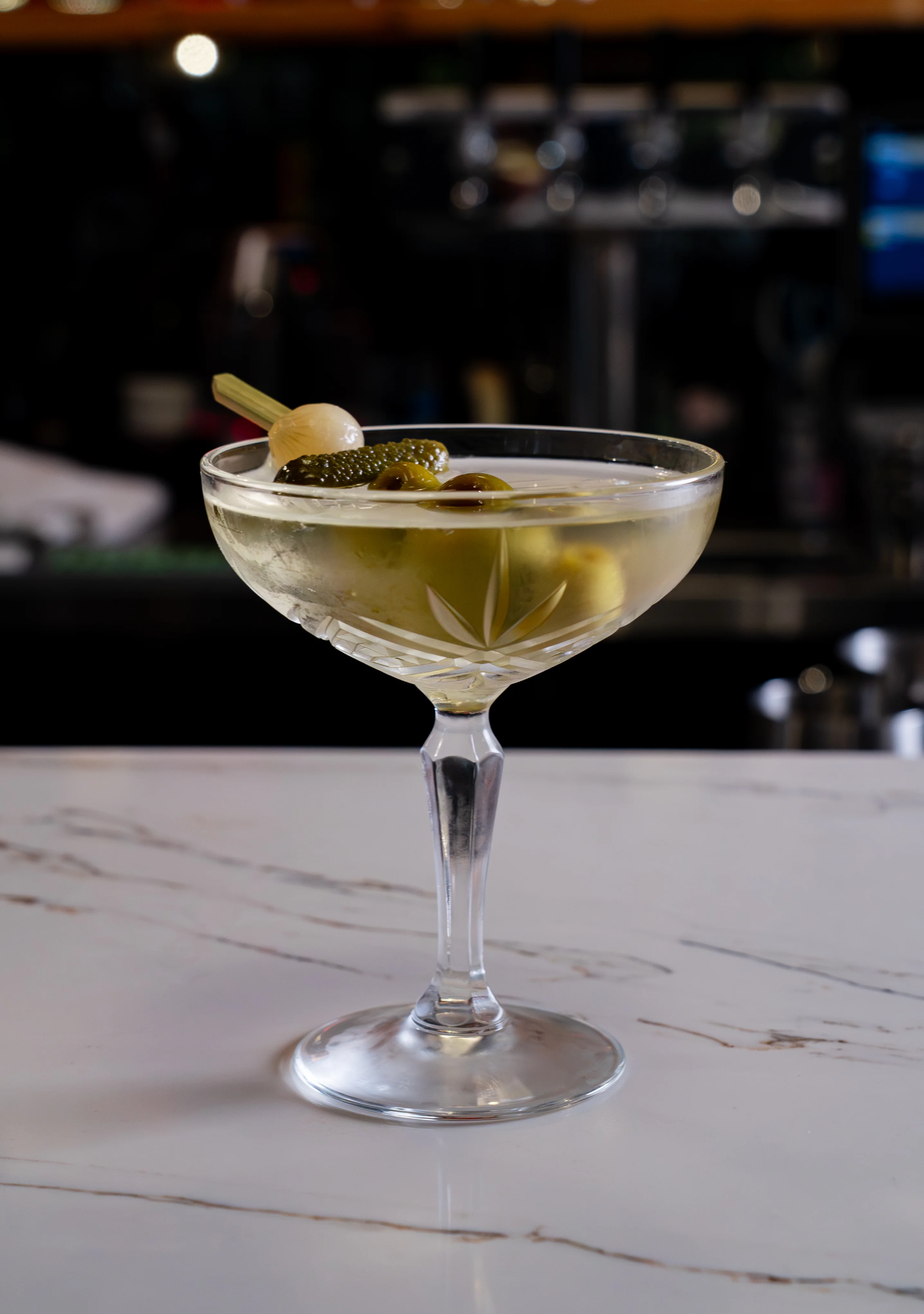 Dirty Martini cocktail served in a stylish glass with garnishes.