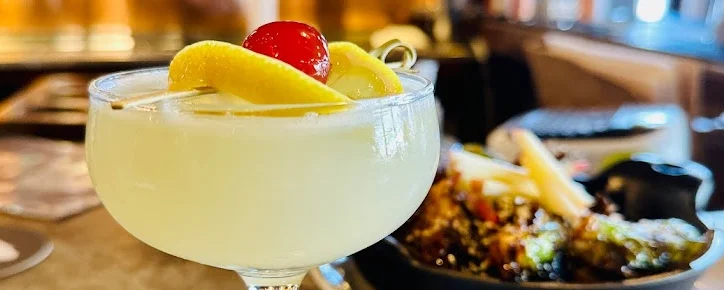 Classic cocktail garnished with lemon and cherry