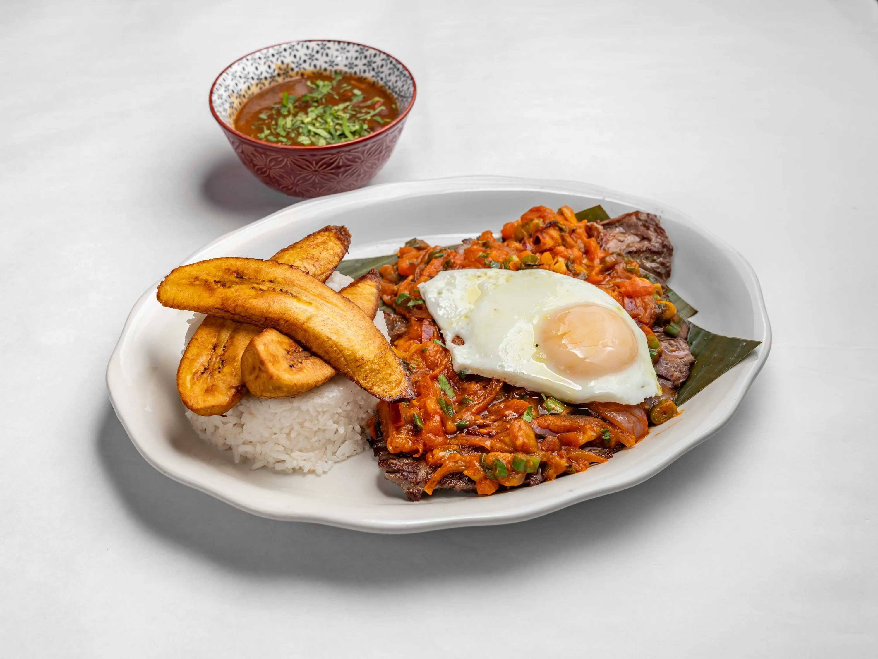 bistec al caballo, flap meat, ahogado sauce, fried egg, rice, beans and sweet plantain