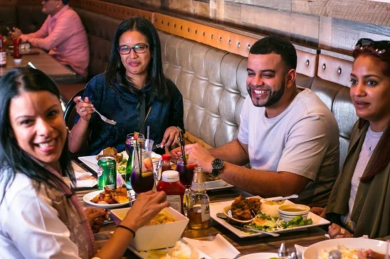 Group enjoying a meal in a vibrant restaurant setting