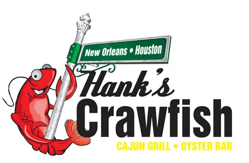 A large bowl filled with crawfish, served in a bag with a cup of dipping sauce. The setting is casual with a bar in the background.