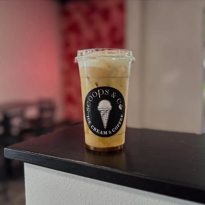 Iced coffee drink in a clear cup at a cozy café