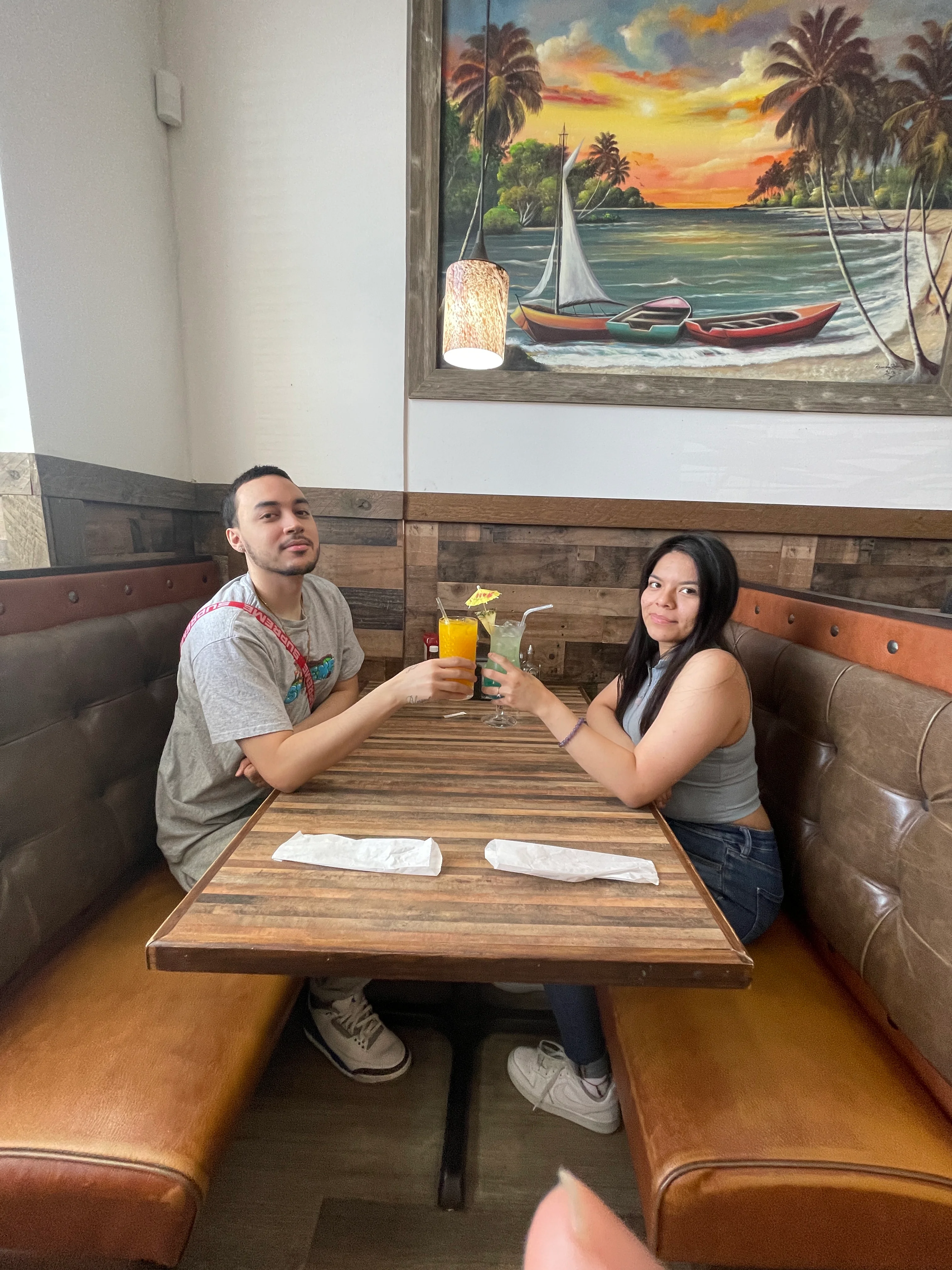 Two people enjoying drinks at a cozy restaurant table.