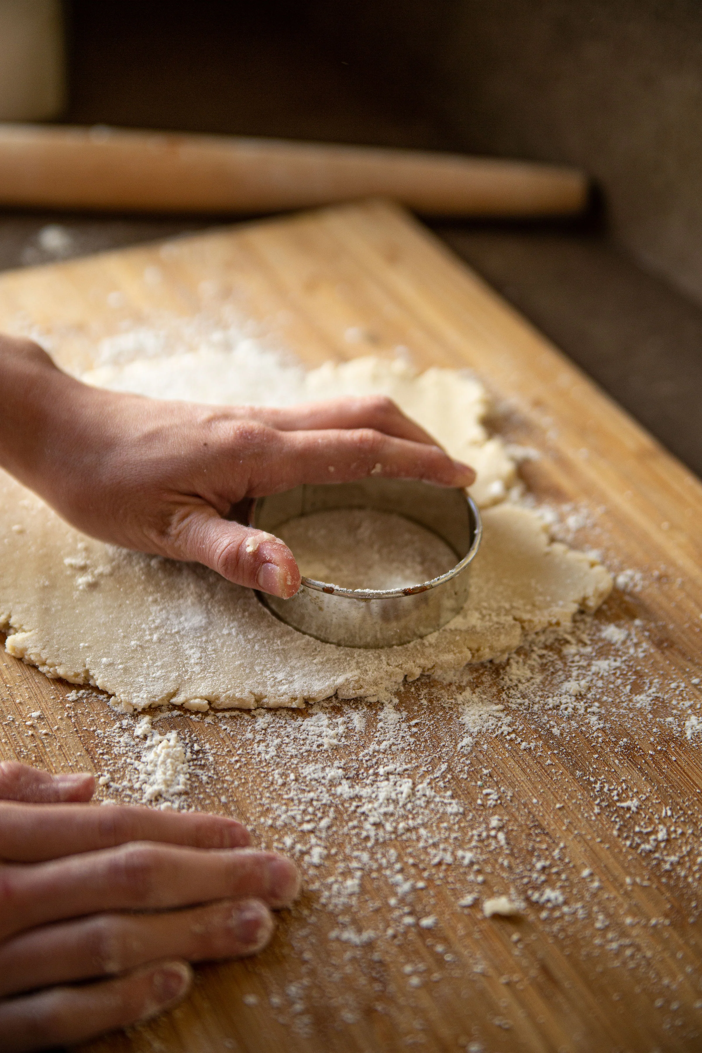 Baker cutting dough with a round cookie cutter