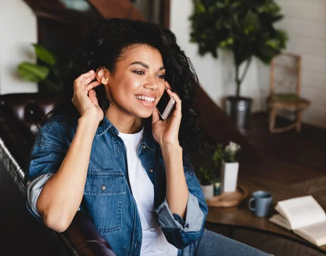 Smiling woman on phone in cozy living room