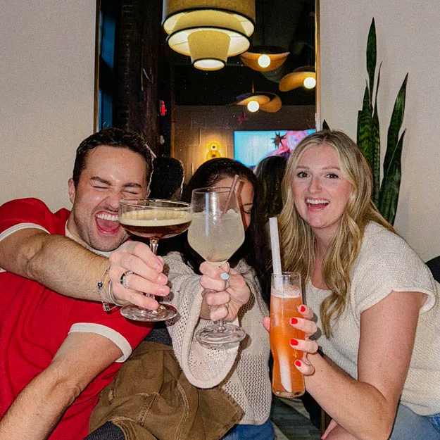Group of friends toasting with drinks in Vinyl