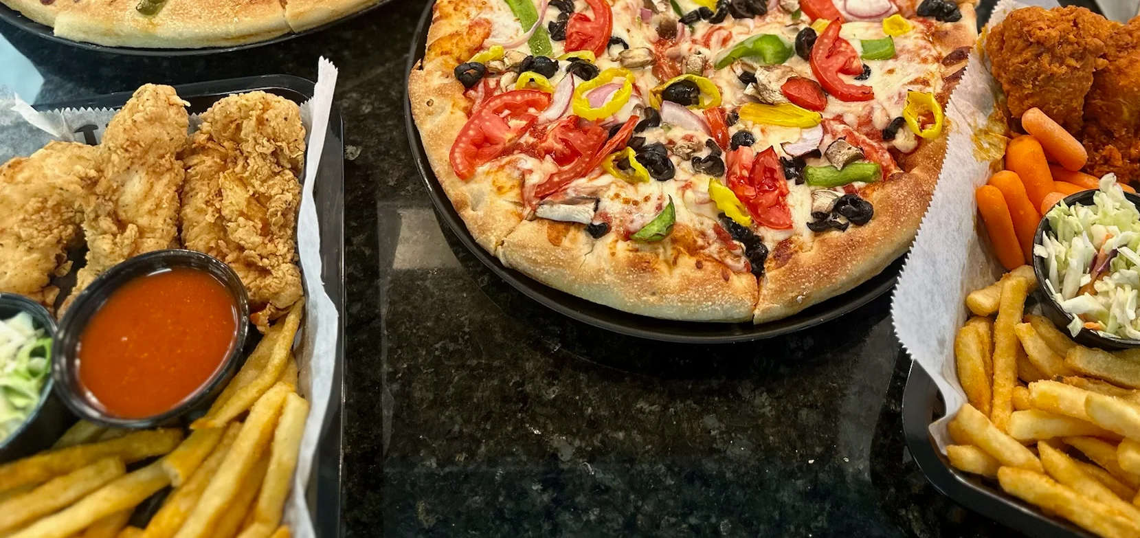 Assorted pizzas and fried chicken platter in a casual dining setting