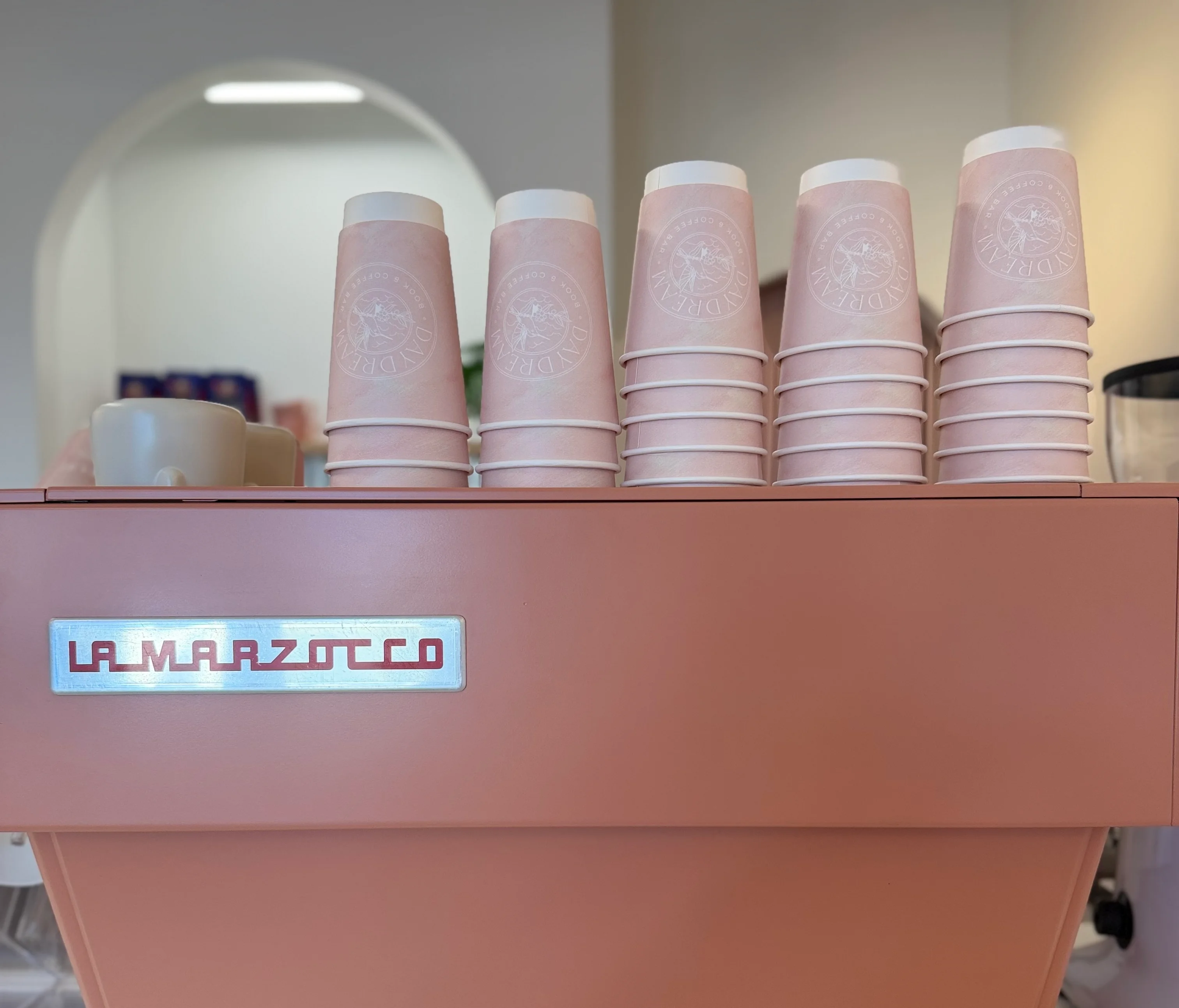 La Marzocco espresso machine with pink cups in a modern café