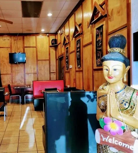 Cozy restaurant interior with wooden decor and welcoming statue